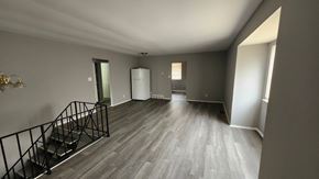 Cincinnati apartment for rent - A spacious room with a staircase and a white refrigerator.