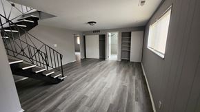 Cincinnati apartment for rent - A spacious room with a staircase on the left and a door on the right.