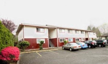Vancouver apartment for rent - an apartment building with cars parked in a parking lot