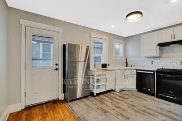 Minneapolis apartment for rent - a kitchen with a stainless steel refrigerator and white cabinets