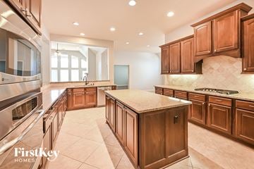 Spring house for rent - a large kitchen with wooden cabinets and stainless steel appliances