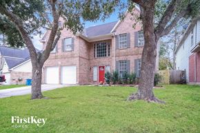 Humble house for rent - a large brick house with two trees in front of it