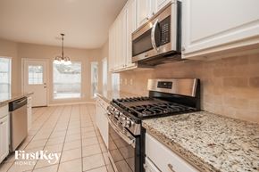 Humble house for rent - an updated kitchen with granite counter tops and a stove and microwave