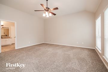 Humble house for rent - a spacious living room with carpet and a ceiling fan