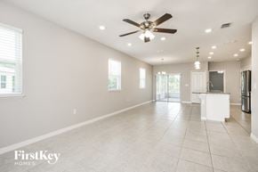 Kissimmee house for rent - an empty kitchen and living room with a ceiling fan