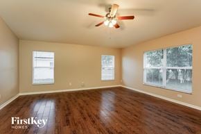 Cape Coral house for rent - the spacious living room with hardwood floors and a ceiling fan