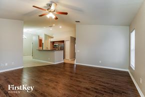 Cape Coral house for rent - an empty living room with wood flooring and a ceiling fan