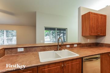 Cape Coral house for rent - a kitchen with wooden cabinets and a sink and a window
