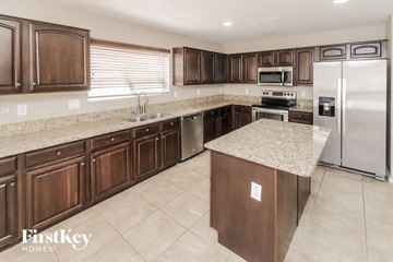 Maricopa house for rent - a large kitchen with stainless steel appliances and granite counter tops