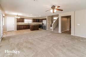 Maricopa house for rent - an empty living room and kitchen with a ceiling fan