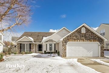 Greensboro house for rent - a brick house with a white garage door in the snow