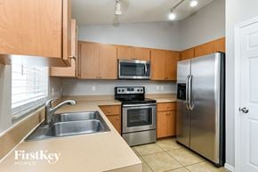 Winter Haven house for rent - a kitchen with stainless steel appliances and wooden cabinets