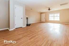 Summerville house for rent - A spacious room with wooden flooring and a ceiling fan.