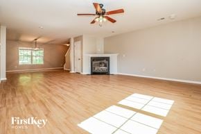 Summerville house for rent - A spacious room with a fireplace and a ceiling fan.