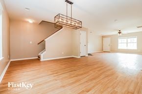 Summerville house for rent - A large empty room with wooden floors and a staircase.