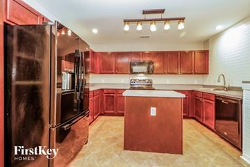 Summerville house for rent - A kitchen with red cabinets and a wooden island.