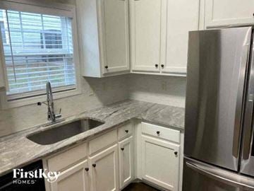 Jefferson house for rent - a kitchen with white cabinets and a sink and a refrigerator