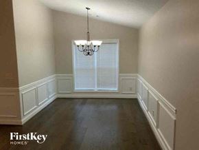 Jefferson house for rent - a empty dining room with a large window and a chandelier