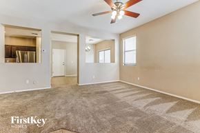 Gilbert house for rent - A spacious room with a fan and carpeted floor.