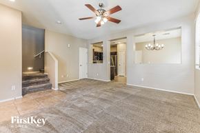Gilbert house for rent - A spacious living room with a carpeted floor and a ceiling fan.