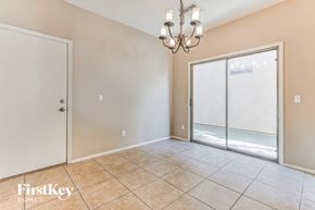 Gilbert house for rent - A room with a chandelier, sliding glass doors, and a tiled floor.
