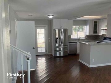 Mesa house for rent - a kitchen with a stainless steel refrigerator and a staircase