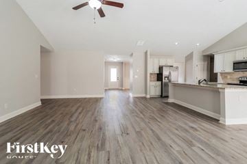 Pendergrass house for rent - A spacious kitchen and living room with wooden floors and a ceiling fan.