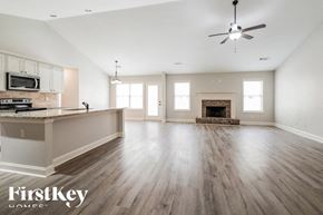 Pendergrass house for rent - A spacious living room with wood flooring and a fireplace.