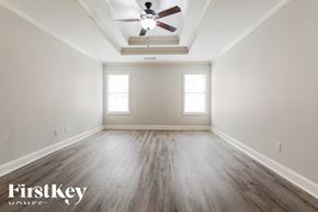 Pendergrass house for rent - A spacious room with a ceiling fan and wooden flooring.