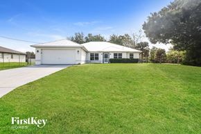 Lehigh Acres house for rent - a white house with a lawn in front of it