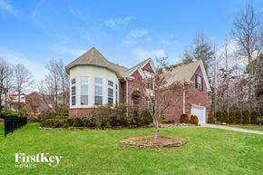 Jamestown house for rent - A large house with a well-manicured lawn and a FirstKey Homes logo.