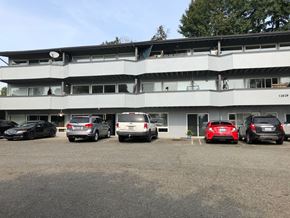 Bellevue apartment for rent - a large white building with cars parked in front of it