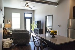 Ames apartment for rent - A modern kitchen with a grey chair and a table with a bowl of fruit on it.