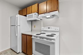 Tacoma apartment for rent - a kitchen with white appliances and wood cabinets and a refrigerator