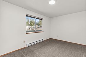 Tacoma apartment for rent - the living room has a large window and a gray carpet
