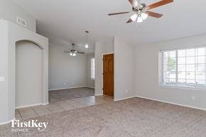 Mesa house for rent - an empty living room with a ceiling fan and a door