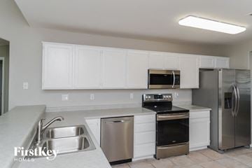 Mesa house for rent - a kitchen with stainless steel appliances and white cabinets