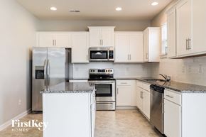 Mooresville house for rent - a white kitchen with stainless steel appliances and white cabinets
