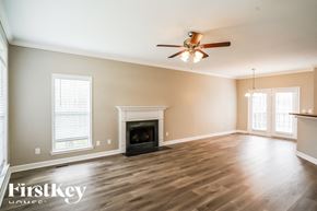 Gallatin house for rent - A spacious room with a fireplace and a ceiling fan.