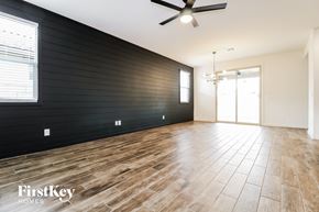 Surprise house for rent - an empty living room with a black accent wall and wood floors