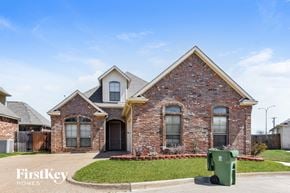 Arlington house for rent - A brick house with a green trash bin in front.