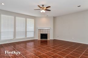 Arlington house for rent - A room with a fireplace and a ceiling fan.