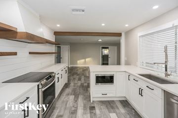Glendale house for rent - A modern kitchen with white cabinets and a checkered floor.