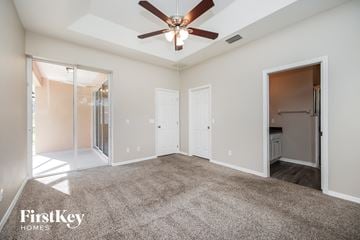 North Port house for rent - a spacious living room with carpet and a ceiling fan