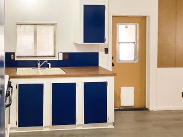 Show Low house for rent - A kitchen with blue and white cabinets and a wooden counter.