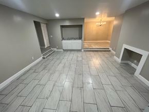 Decatur apartment for rent - A spacious room with a wooden floor and a chandelier.