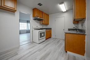 Monterey Park apartment for rent - an empty kitchen with white appliances and wooden cabinets