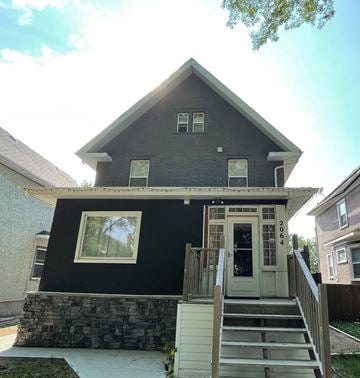 Regina apartment for rent - the exterior of a house with a black facade and stairs