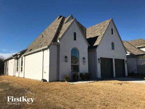 Aledo house for rent - A white house with a black roof and a garage door is shown.