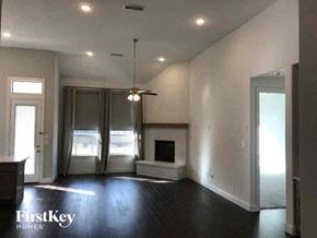 Aledo house for rent - A spacious living room with a fireplace and sliding glass doors.